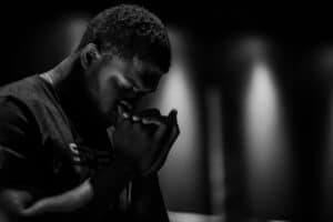 Exploring the Transformational Power of Surrender man with clasped hands toward face and eyes closed in prayer